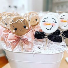 some kind of cake pops in a bucket with bow ties and snowmen on them