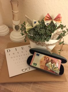 a potted plant sitting on top of a table next to a calendar and money