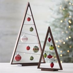 two wooden christmas trees with ornaments on them