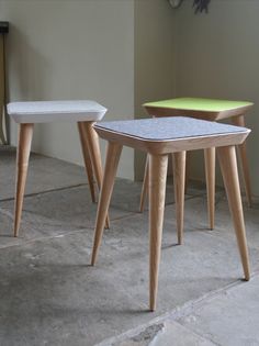 three wooden tables sitting on top of a stone floor