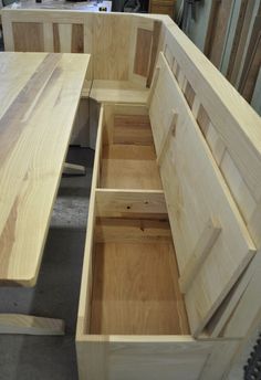 the bench is made from wood and has two open compartments on each side that are filled with drawers