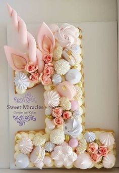 a cake decorated to look like the letter f with flowers and seashells on it