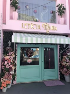 there is a pink and green building with flowers on the front door that says letticia marina