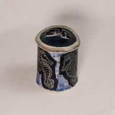 a blue and white ceramic container with two seahorses on it