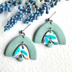 Adorn your ears with these stunning Floral Polymer Clay Earrings in a beautiful combination of blue, purple, and turquoise hues. These Dainty Botanical Handmade Jewelry pieces are the perfect accessory to elevate any outfit. Lightweight and easy to wear all day long, these earrings are not only fashionable but also comfortable. Add a touch of nature-inspired beauty to your wardrobe with these unique and eye-catching fashion accessories. They could be a perfect treat for yourself or the perfect g Unique Blue Drop Earrings, Unique Blue Dangle Earrings, Modern Turquoise Dangle Earrings, Artsy Green Dangle Jewelry, Artsy Green Drop Earrings, Green Artsy Drop Earrings, Artsy Blue Dangle Earrings, Artsy Green Teardrop Earrings, Turquoise Polymer Clay Earrings