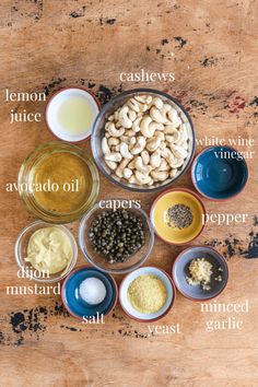 the ingredients for this recipe are displayed in bowls on a wooden counter top, including cashews, avocado oil, capers, salt and pepper