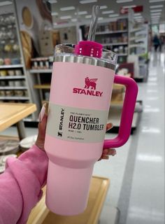 a person holding a pink tumbler in a store