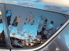 the back window of a car that has been decorated with honeycombs and words