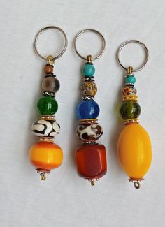 three key chains with different colored beads on them