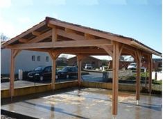 a wooden gazebo sitting in the middle of a parking lot