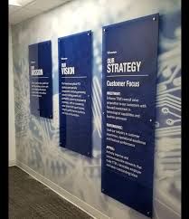 three blue signs on the wall in an office building with information about their strategy and how to use them