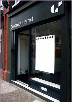 there is a sign in the window that says concrete hemmitt, and it's on the sidewalk