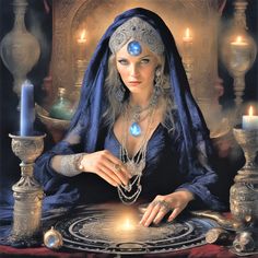 a woman sitting at a table with candles in front of her and wearing a headdress