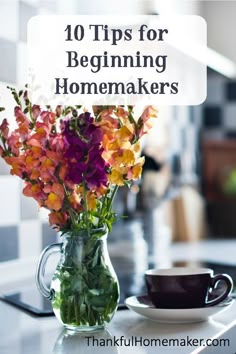 a vase filled with flowers sitting on top of a table next to a coffee cup