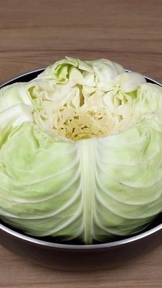 a bowl filled with cabbage on top of a wooden table