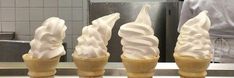 four ice cream cones sitting on top of a counter