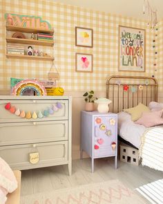 a child's bedroom decorated in pastel colors and gingham wallpaper