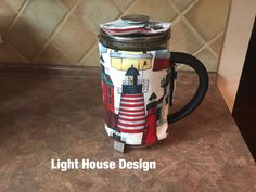 there is a coffee mug with a lighthouse design on it