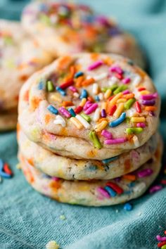 several cookies with sprinkles and colored powdered sugar are stacked on top of each other