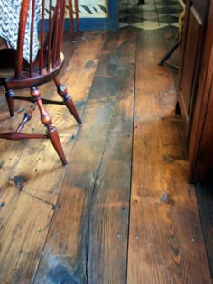 a wooden rocking chair sitting on top of a hard wood floor