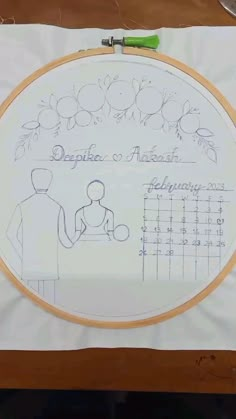 an embroidery pattern on a piece of white paper with a drawing of a man holding a baby