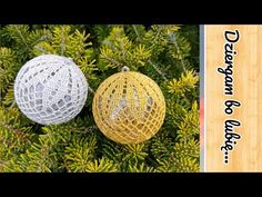 two ornaments hanging from a tree with pine needles