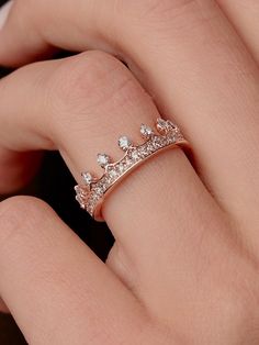 a woman's hand wearing a ring with three small white diamonds on the side