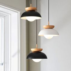 three lights hanging from the ceiling in a room with white walls and wood trimmings