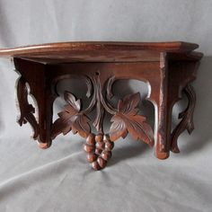 an ornate wooden shelf with grapes on it