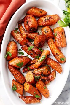 roasted carrots with herbs in a white bowl on a marble countertop, ready to be eaten