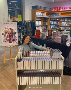 a woman standing behind a display case filled with books