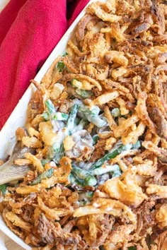 a casserole dish with green beans, onions and cream cheese on the side