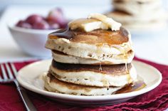 a stack of pancakes on a plate with syrup drizzled over the top