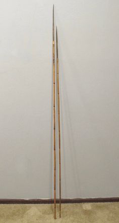 two wooden sticks leaning up against a wall