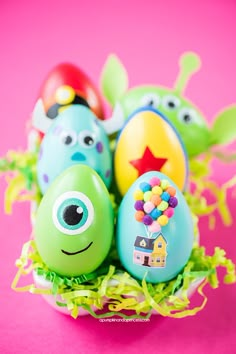 three decorated eggs in a nest on a pink background