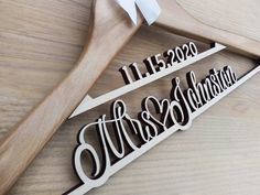 two wooden wedding hangers with names on them