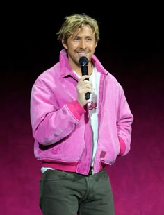 a man in a pink jacket holding a microphone