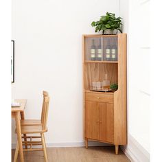 a wooden cabinet sitting in the corner of a room next to a table and chairs