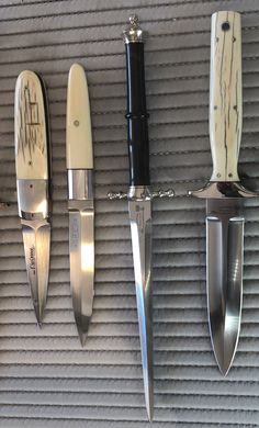 four knives are hanging on the wall next to each other