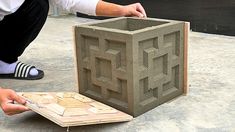 a man kneeling down next to a cement block that has been cut into smaller squares