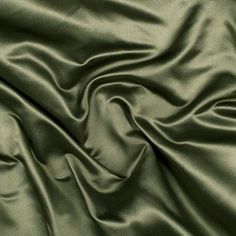 a close up view of a green satin fabric with very soft folds and wrinkles