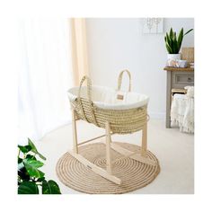 a white wicker baby bassinet sitting on top of a rug in front of a window