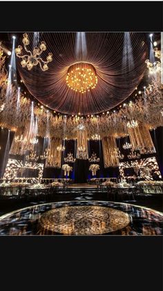 a large chandelier hanging from the ceiling in a room with tables and chairs