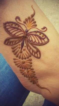 a woman's hand with a butterfly tattoo on it