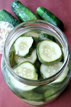 cucumbers and rice in a jar on a table next to pickle slices