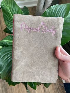 a person holding up a book with the word personal study written in pink on it