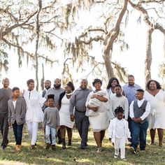 a large group of people standing next to each other in front of trees with moss on them