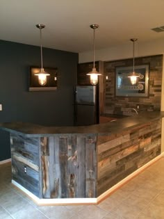 a bar made out of wooden planks in a kitchen with lights hanging from the ceiling