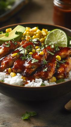 a bowl filled with rice and chicken covered in sauce, garnished with avocado