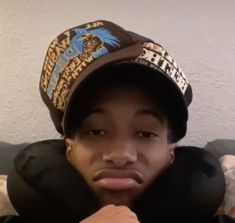 a young man wearing a hat while sitting down